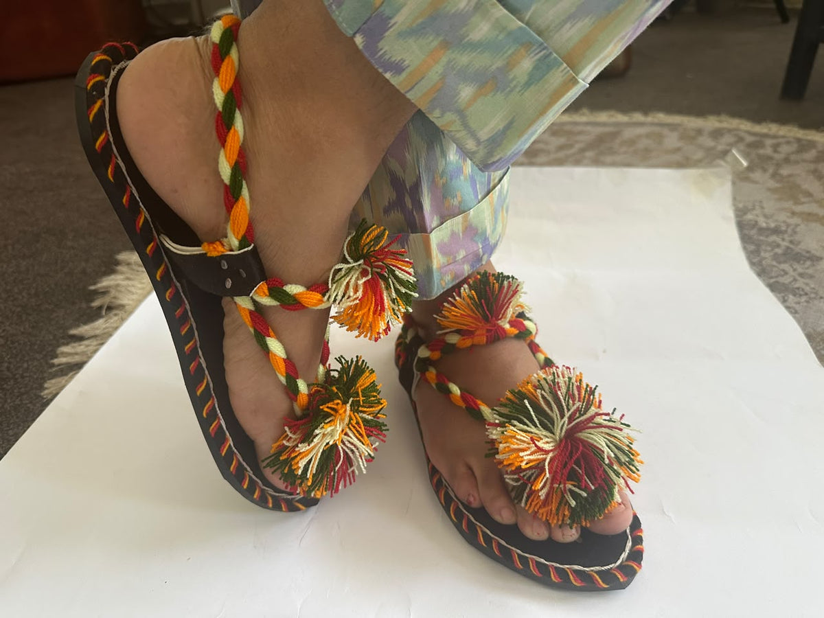 Multicolour pom pom Balochi chappal showing braided back strap and tyre sole